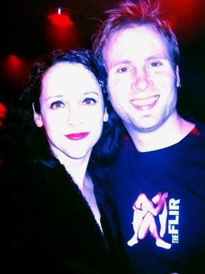 Two people in a dark venue, one wearing the Human Heart shirt